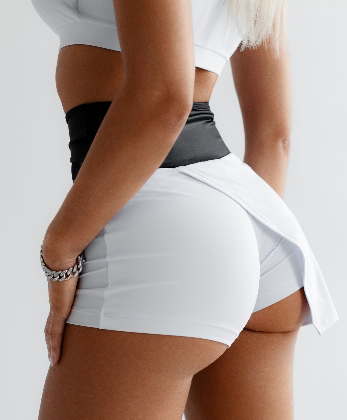 Woman with braided hair displaying gold jewelry.