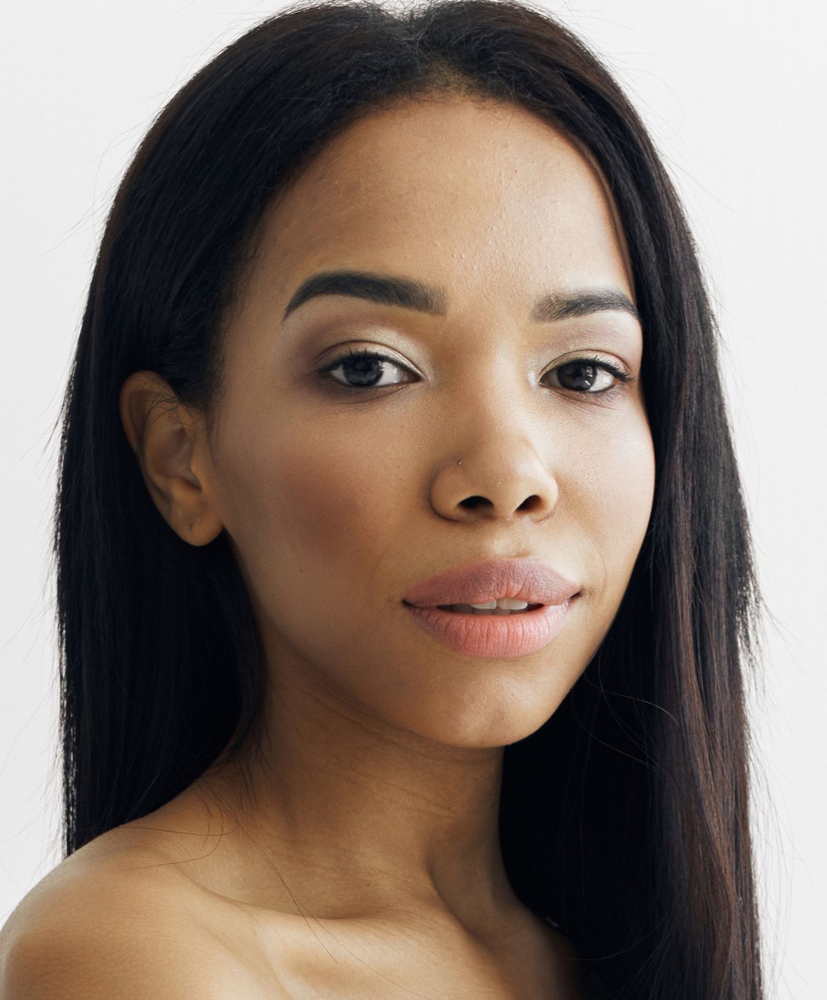 Close-up of a woman relaxing with neutral background.