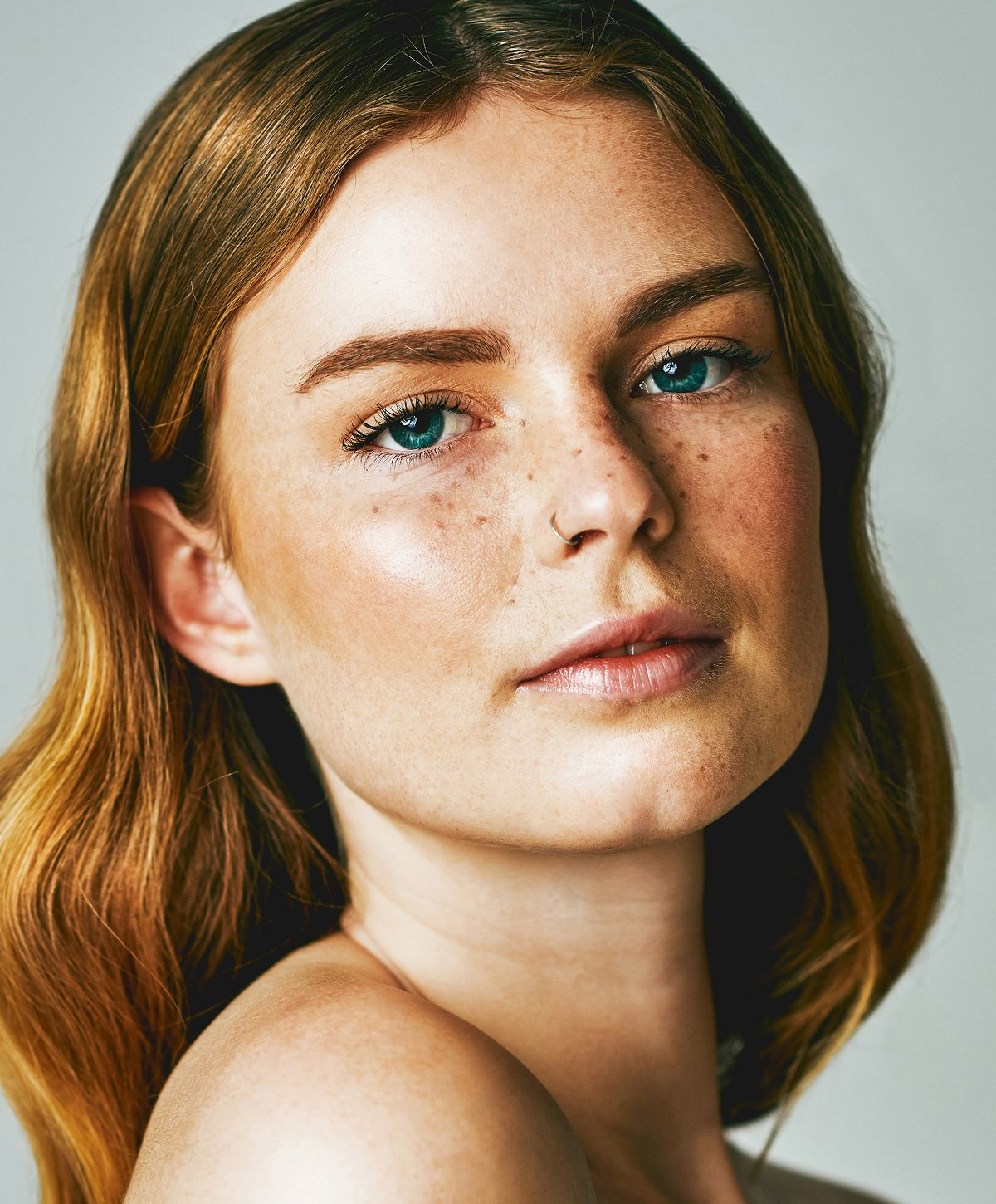 Close-up of a woman relaxing with neutral background.