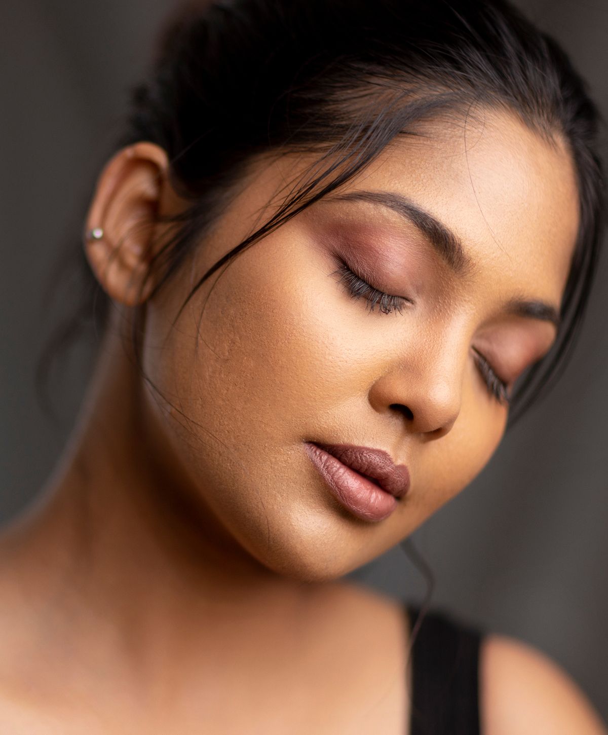Close-up of a woman relaxing with neutral background.