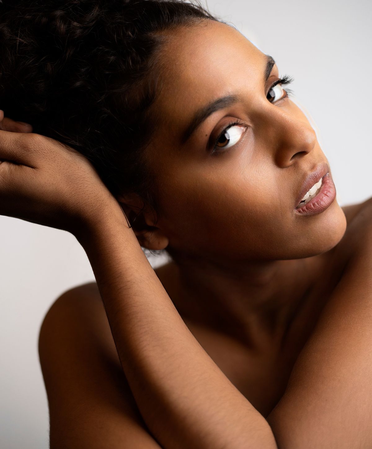 Close-up of a woman relaxing with neutral background.