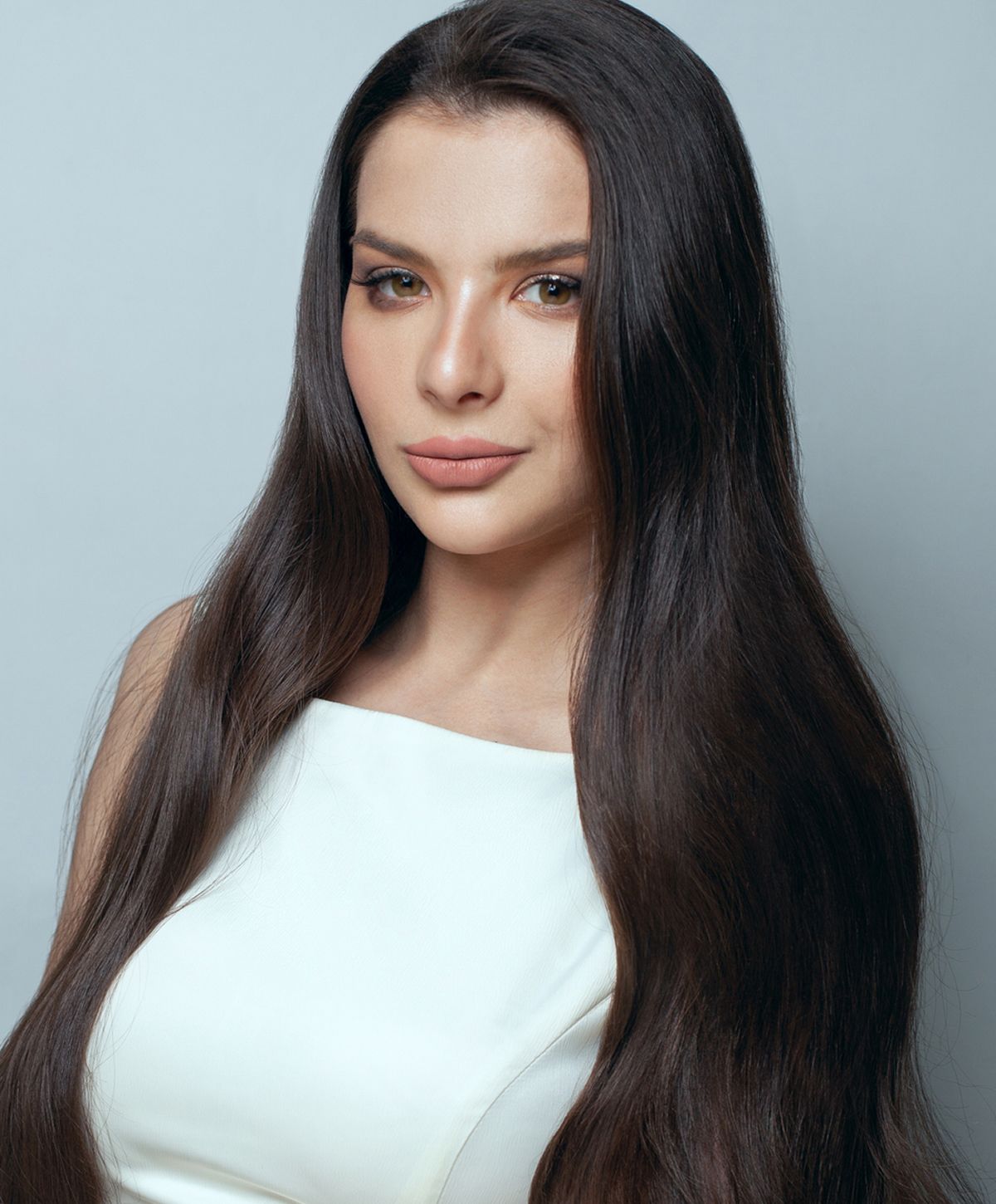 Woman with braided hair displaying gold jewelry.