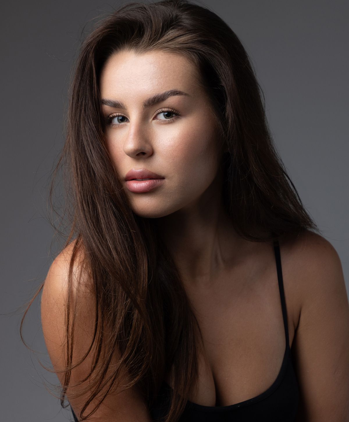 Woman with braided hair displaying gold jewelry.