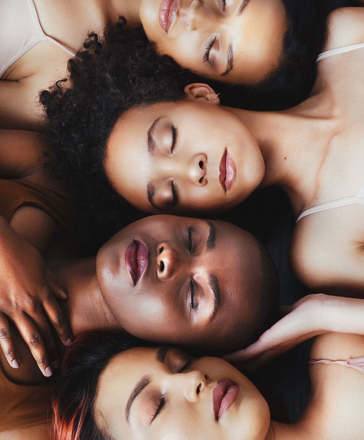 Model sitting gracefully, smiling, wearing white outfit.