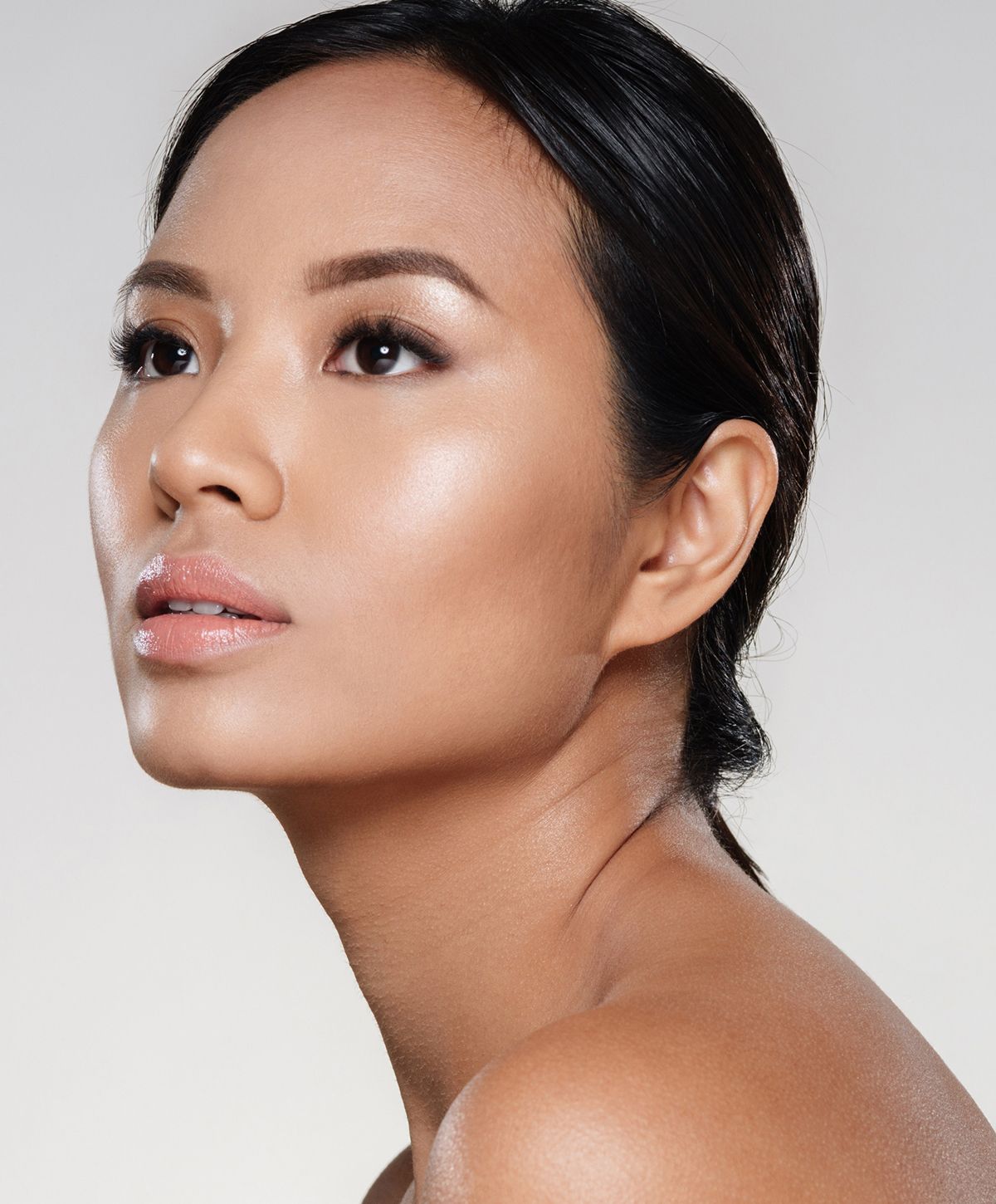 Model in white attire, seated, profile view.