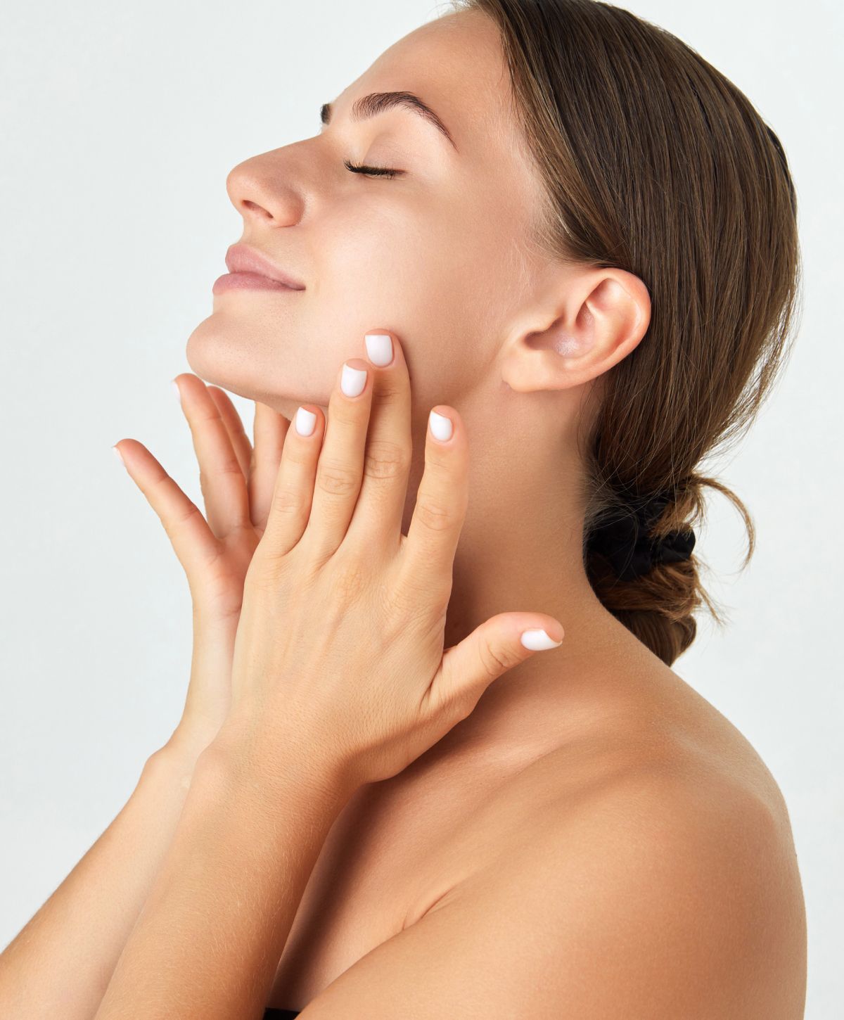 Close-up of a woman relaxing with neutral background.