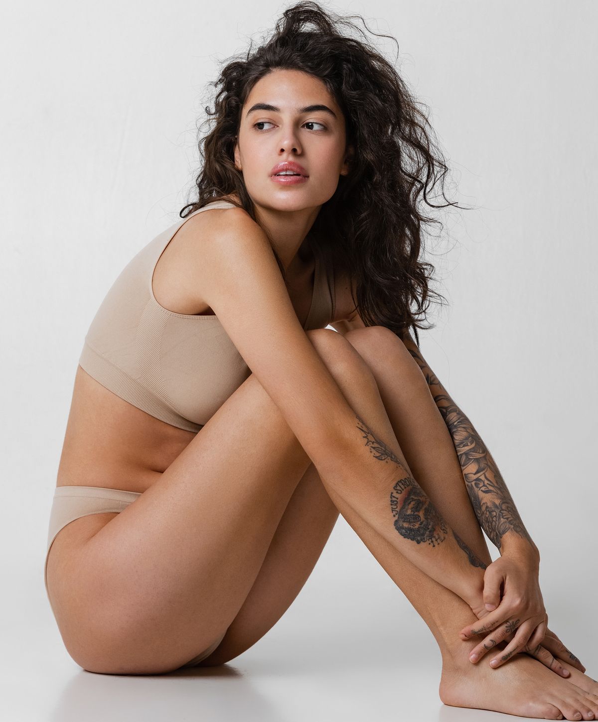 Woman in nude lingerie posing elegantly.