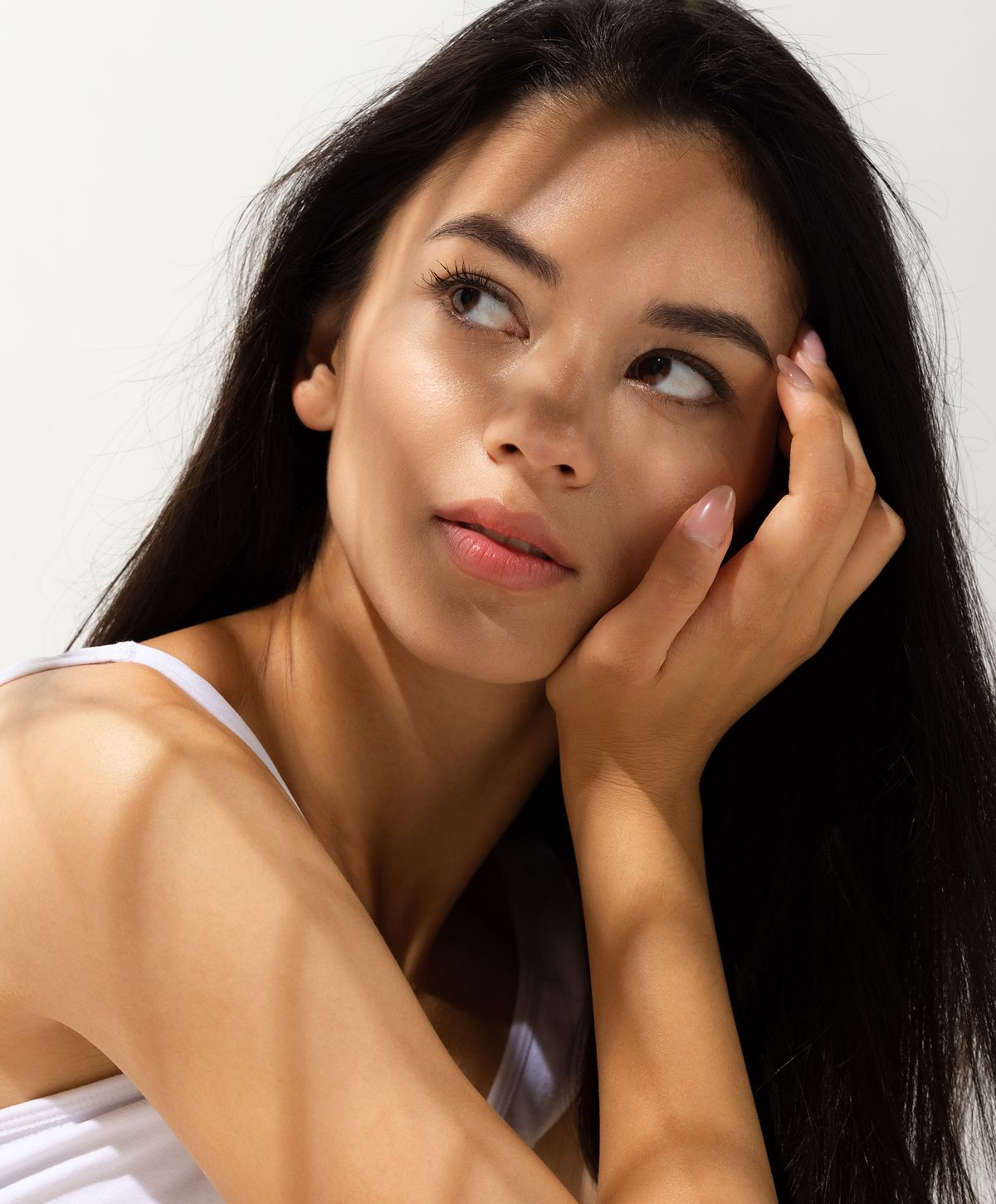 Woman with braided hair displaying gold jewelry.
