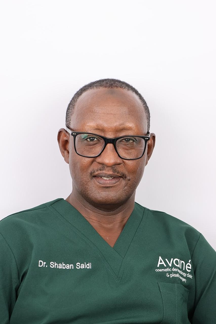 Man in formal attire against purple background.