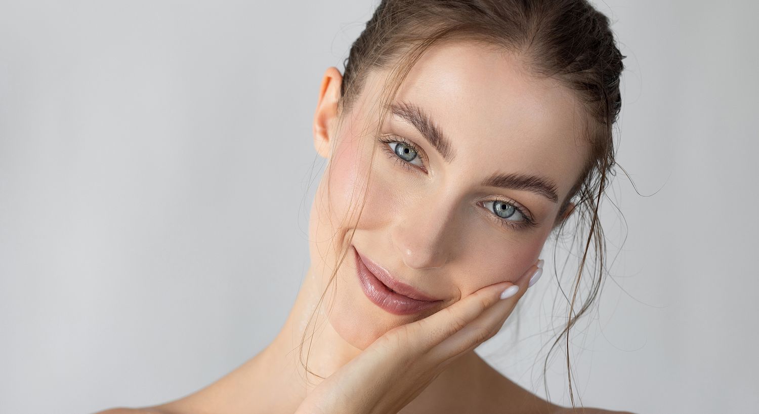 Smiling woman with blue eyes and hand on face